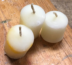 Tops of longer candles trimmed down to the height of a votive candle holder