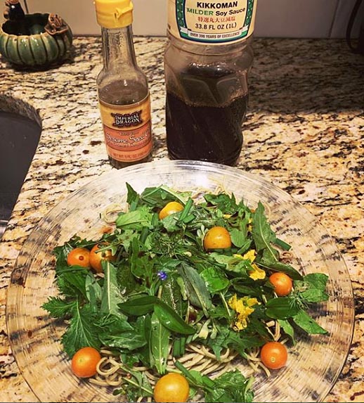 Fresh picked salad from the backyard with cherry tomatoes, dill, arugula, chives, romaine, mustard greens, edible flowers and wild greens.